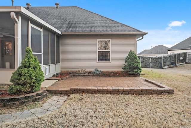 rear view of house featuring a sunroom, a yard, and a patio