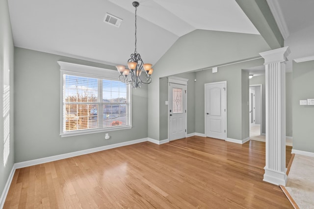 unfurnished dining area with hardwood / wood-style floors, an inviting chandelier, vaulted ceiling, and decorative columns