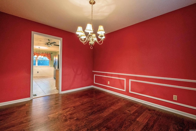 unfurnished dining area featuring ceiling fan with notable chandelier and hardwood / wood-style flooring