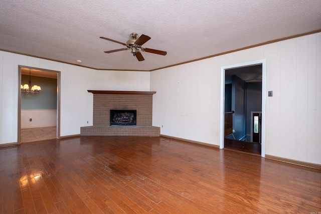 unfurnished living room with elevator, a textured ceiling, a fireplace, ceiling fan with notable chandelier, and hardwood / wood-style flooring