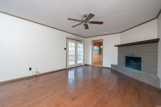 unfurnished living room with french doors, ceiling fan, dark hardwood / wood-style floors, a textured ceiling, and a fireplace