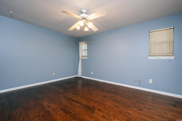 empty room with ceiling fan, dark hardwood / wood-style flooring, and a textured ceiling