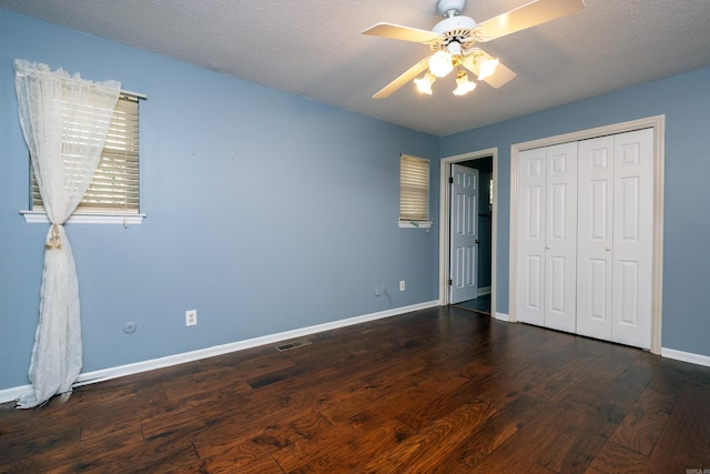 unfurnished bedroom with a textured ceiling, a closet, ceiling fan, and dark wood-type flooring