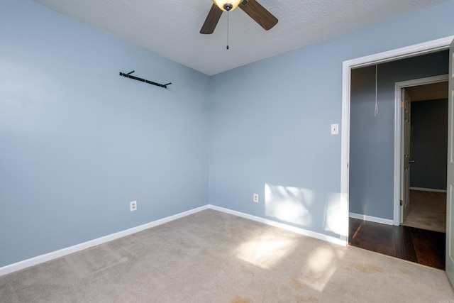 carpeted empty room featuring a textured ceiling and ceiling fan