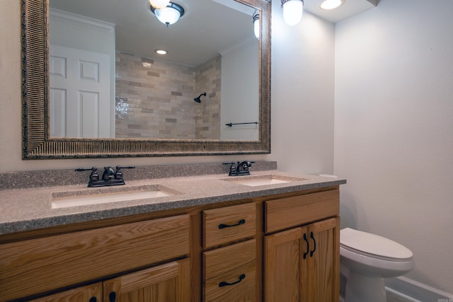 bathroom with a shower, crown molding, vanity, and toilet