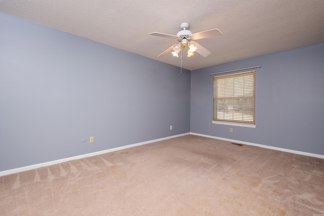 carpeted spare room featuring a textured ceiling and ceiling fan