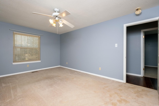 carpeted spare room with ceiling fan and a textured ceiling