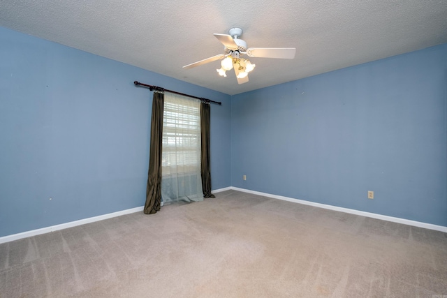 carpeted spare room with a textured ceiling and ceiling fan