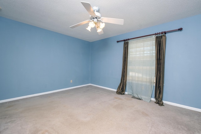 carpeted spare room featuring a textured ceiling and ceiling fan