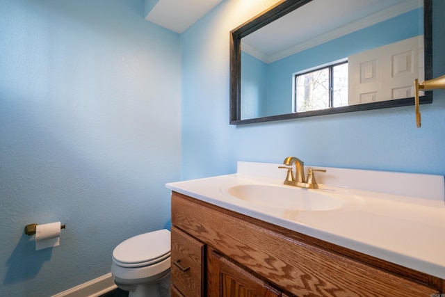 bathroom with vanity, ornamental molding, and toilet