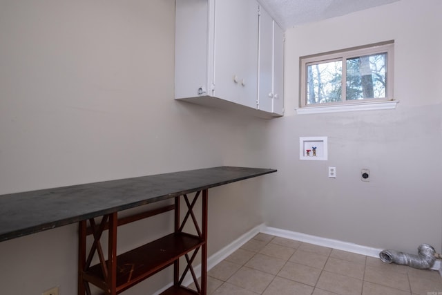 laundry area with cabinets, washer hookup, a textured ceiling, hookup for an electric dryer, and light tile patterned flooring