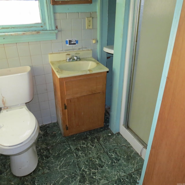 bathroom featuring a shower with door, vanity, and toilet