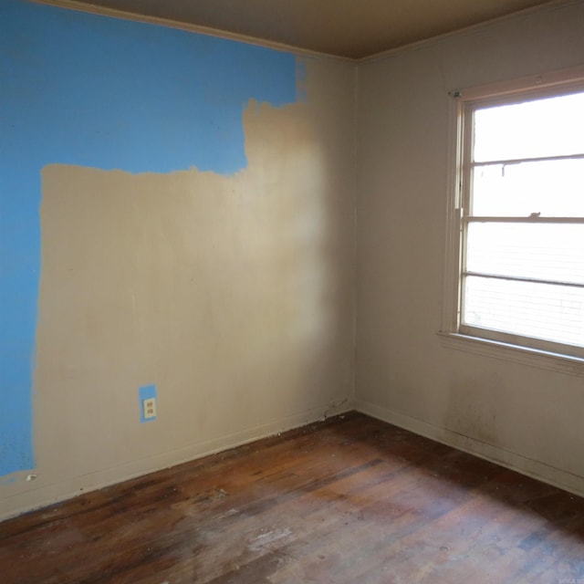 spare room featuring dark hardwood / wood-style floors, a wealth of natural light, and ornamental molding