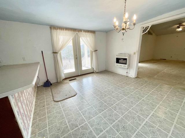 unfurnished living room featuring heating unit, light carpet, french doors, and a chandelier