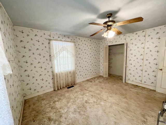 unfurnished bedroom with ceiling fan, a closet, and carpet