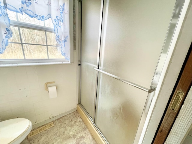 bathroom with an enclosed shower and toilet