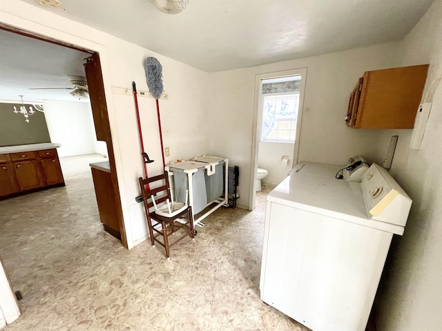 washroom with ceiling fan, washer and dryer, and cabinets