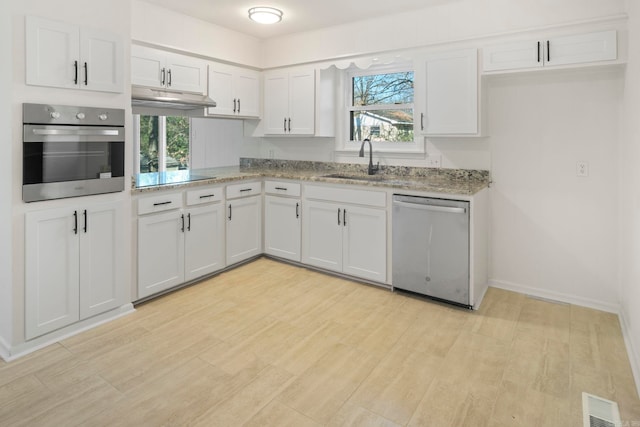 kitchen featuring white cabinets, appliances with stainless steel finishes, plenty of natural light, and sink