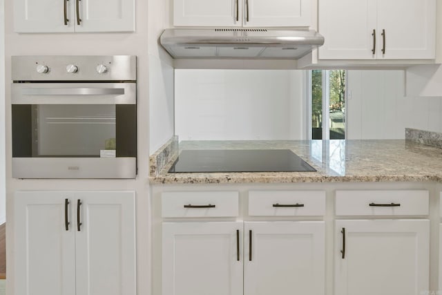 kitchen with black electric stovetop, white cabinetry, and oven