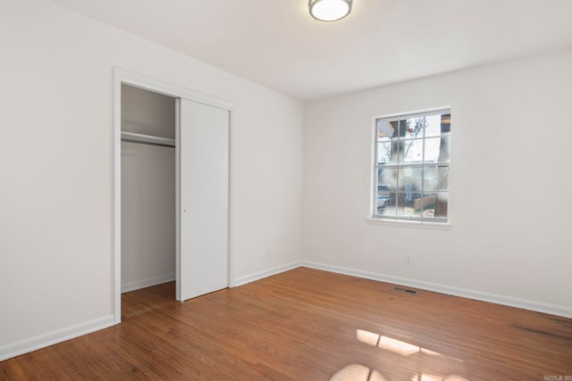 unfurnished bedroom featuring hardwood / wood-style floors and a closet