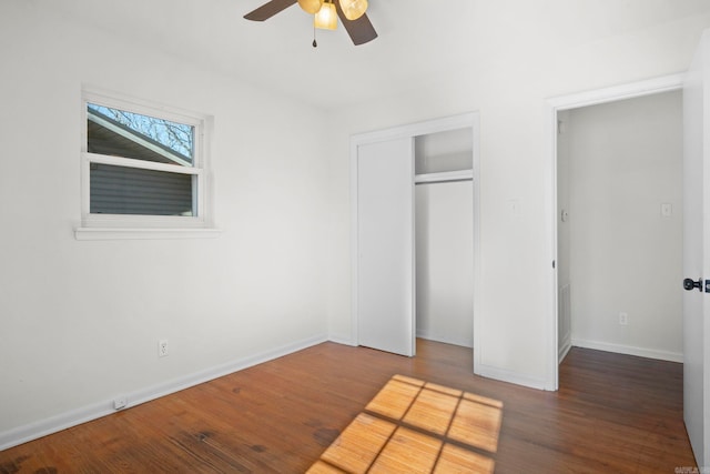 unfurnished bedroom featuring ceiling fan and dark wood-type flooring