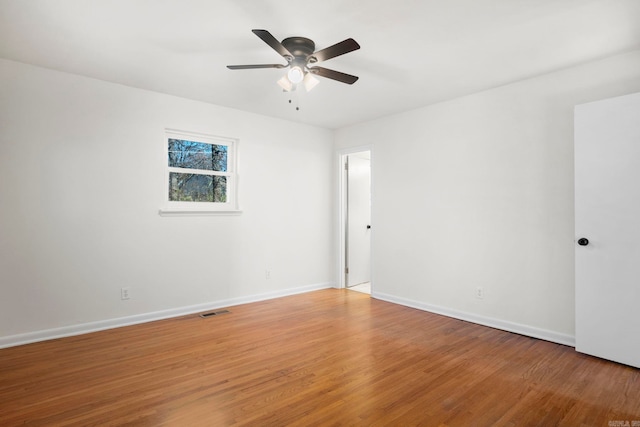 empty room with hardwood / wood-style flooring and ceiling fan