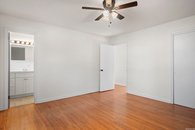 unfurnished bedroom featuring ceiling fan, sink, light hardwood / wood-style flooring, and ensuite bath