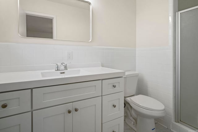 bathroom featuring walk in shower, vanity, tile walls, and toilet