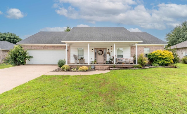 ranch-style house featuring covered porch, a garage, and a front lawn