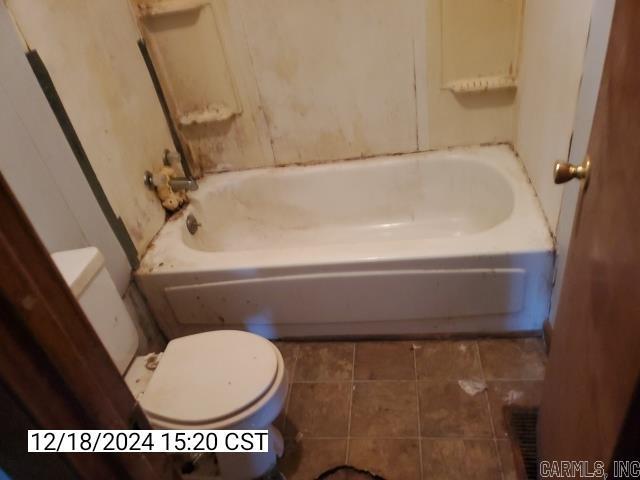 bathroom with tile patterned floors, toilet, and a bathing tub