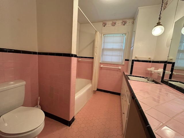 full bathroom with tile patterned floors, toilet, shower / tub combo with curtain, vanity, and tile walls