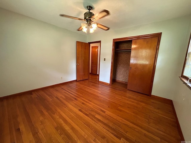 unfurnished bedroom with ceiling fan, a closet, and wood-type flooring