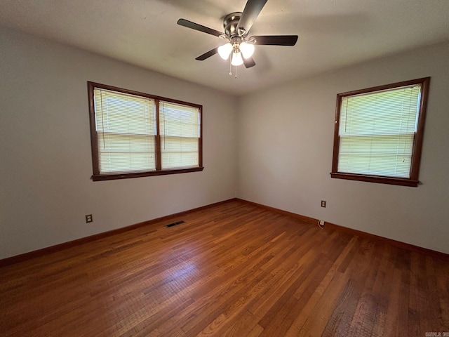 empty room featuring ceiling fan and dark wood-type flooring