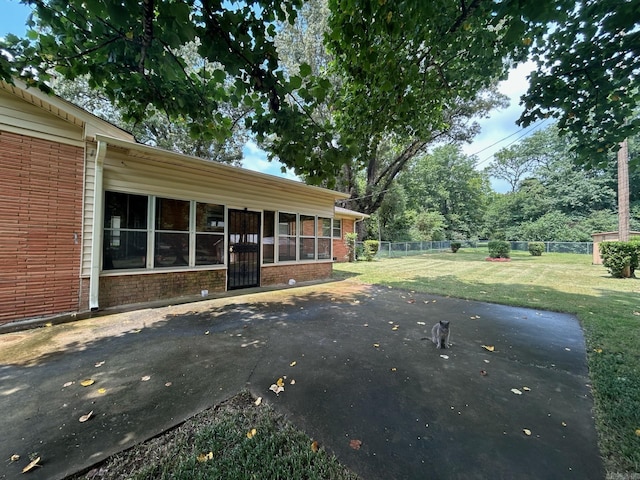 view of yard with a sunroom and a patio area