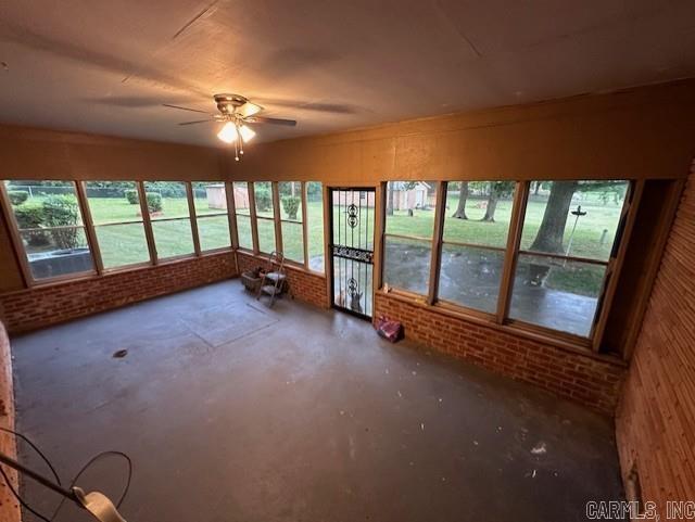 unfurnished sunroom with a wealth of natural light and ceiling fan