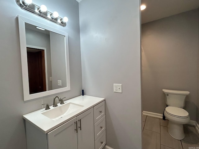 bathroom with tile patterned flooring, vanity, and toilet