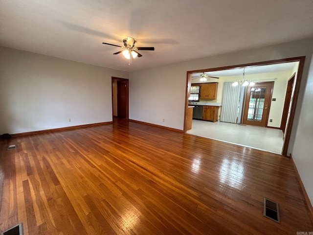 unfurnished living room with hardwood / wood-style floors and ceiling fan with notable chandelier