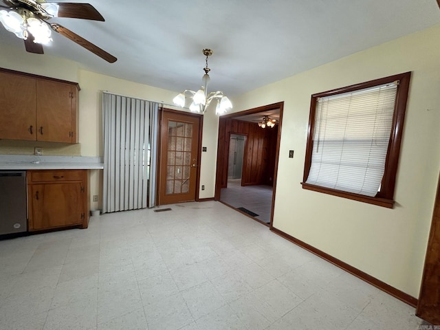 unfurnished dining area with ceiling fan with notable chandelier