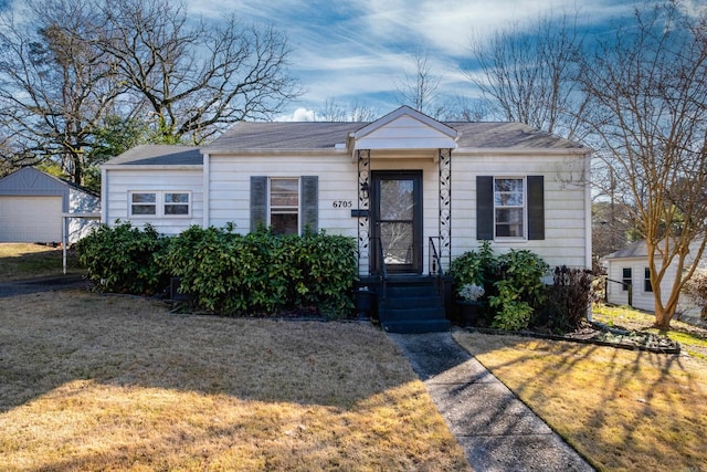 view of front facade featuring an outbuilding, a front yard, and a garage