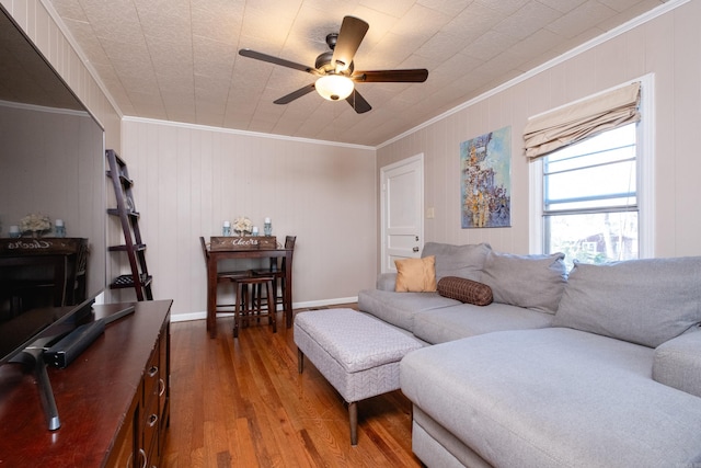 living room with wood-type flooring, ceiling fan, and ornamental molding