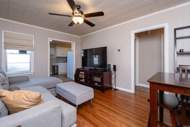 living room featuring hardwood / wood-style flooring, ceiling fan, and ornamental molding