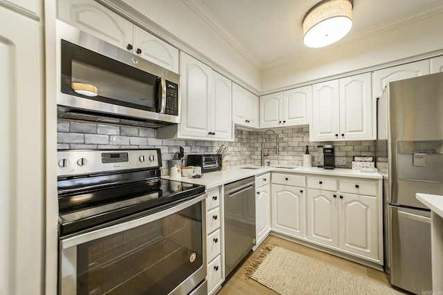 kitchen featuring appliances with stainless steel finishes, backsplash, white cabinetry, and sink