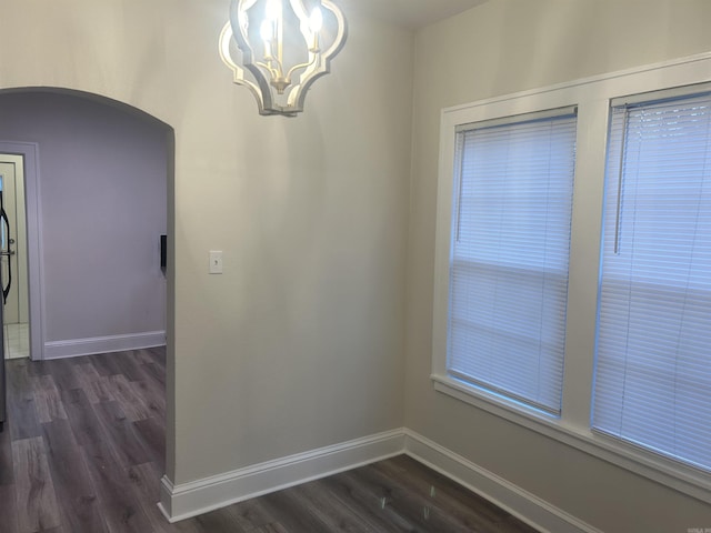 unfurnished dining area featuring dark hardwood / wood-style floors and a notable chandelier