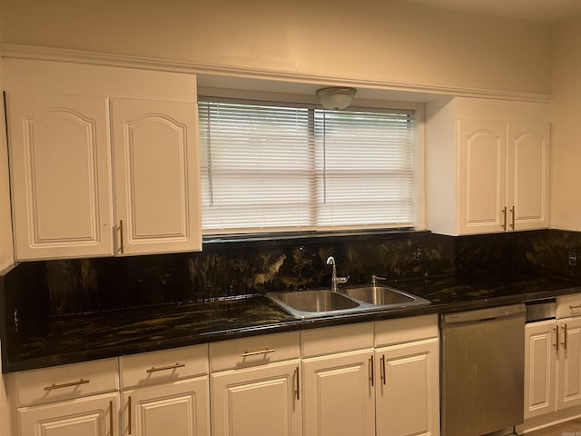 kitchen with stainless steel dishwasher, backsplash, white cabinetry, and sink