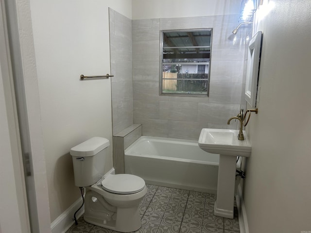 bathroom featuring tile patterned floors, tiled shower / bath, and toilet