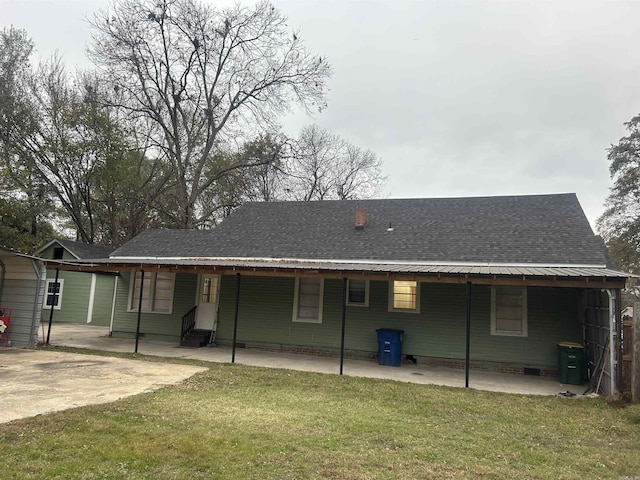 rear view of house with a carport and a lawn