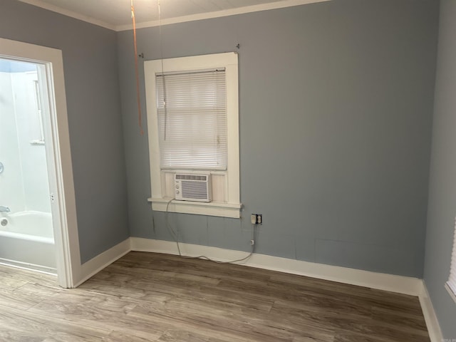 empty room with hardwood / wood-style floors and crown molding