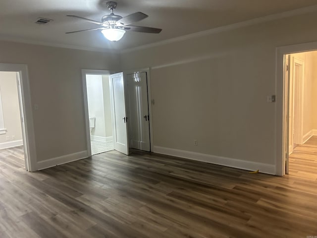 empty room with ceiling fan, dark hardwood / wood-style flooring, and crown molding