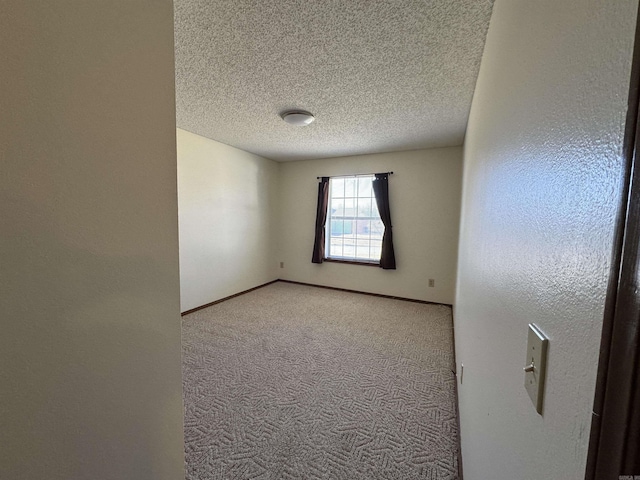 spare room with light carpet and a textured ceiling