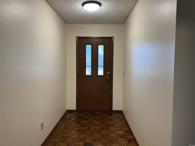 doorway to outside with a textured ceiling and dark parquet floors